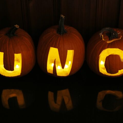 Carved pumpkins that read U-N-C