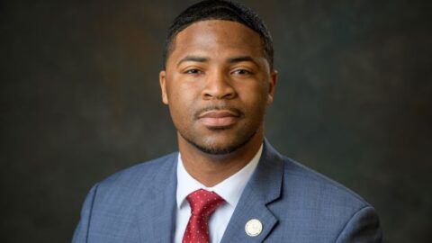 A man in a navy suit and red tie