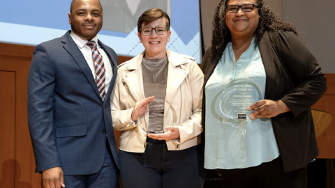 People holding an award at a ceremony