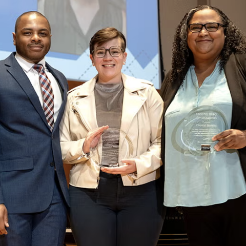 People holding an award at a ceremony