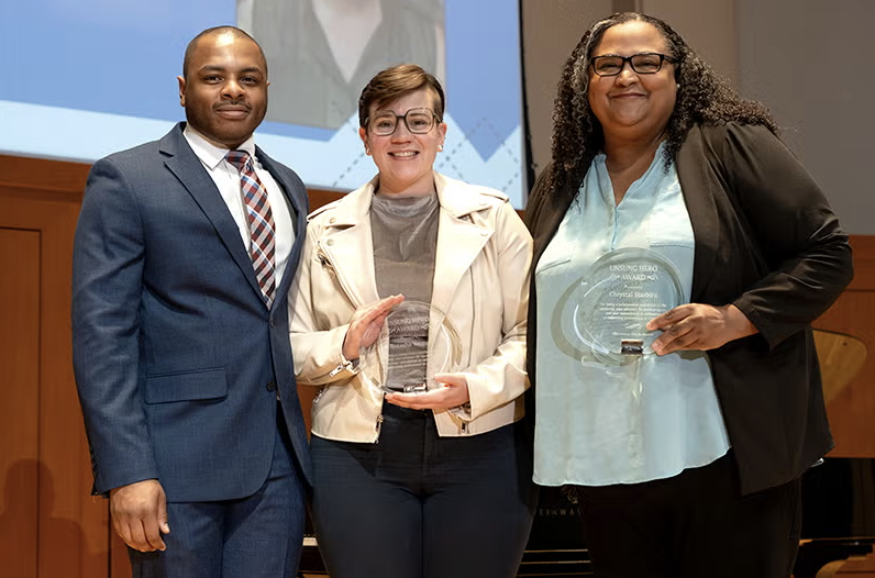 People holding an award at a ceremony